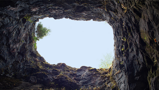 View looking up at the sky from inside of a pit